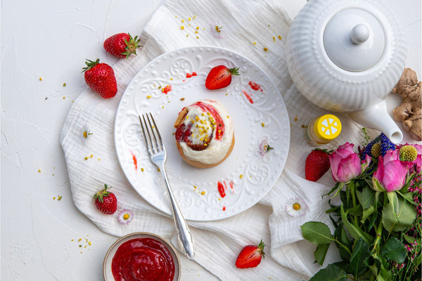 Erdbeerschnecken mit Ingwer Frosting serviert und dekoriert auf einem weißen Teller