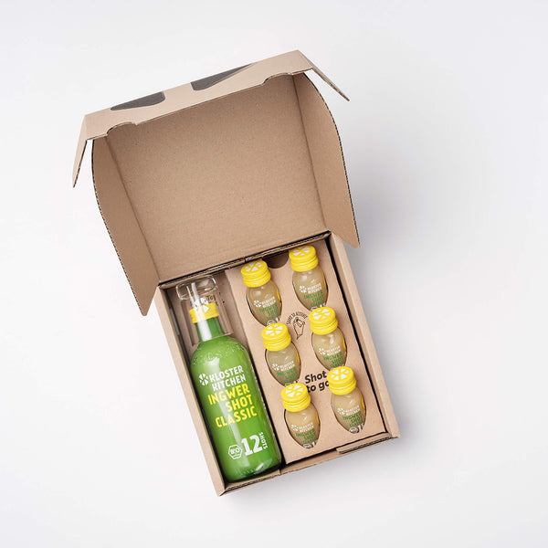 The Ginger Shot Classic box opened so you can see the contents: 1 360 ml bottle of Ginger Shot Classic, 6x 30 ml Ginger Shot Classic + 1 shot glass.